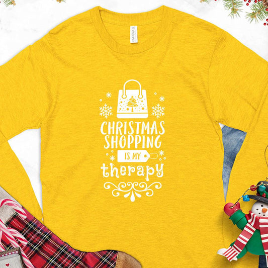 Christmas Shopping Is My Therapy Version 1 Long Sleeves Gold - Graphic long sleeve tee with "Christmas Shopping Is My Therapy" slogan surrounded by festive snowflake designs.
