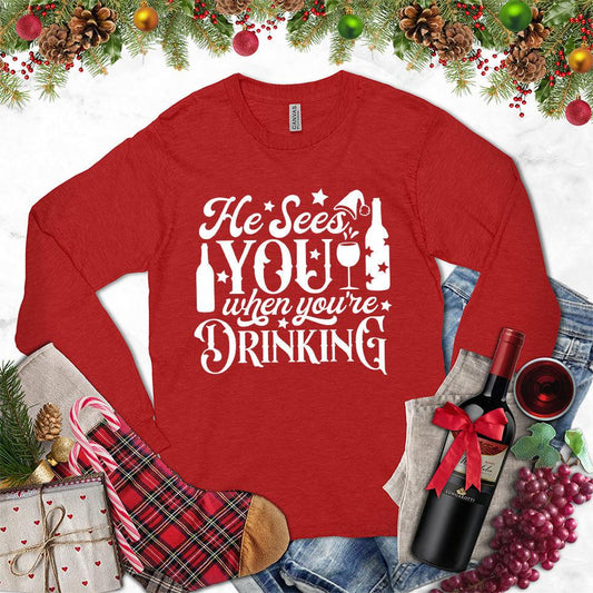 He Sees You When You're Drinking Long Sleeves Red - Humorous long sleeve holiday shirt with festive drinking phrase design
