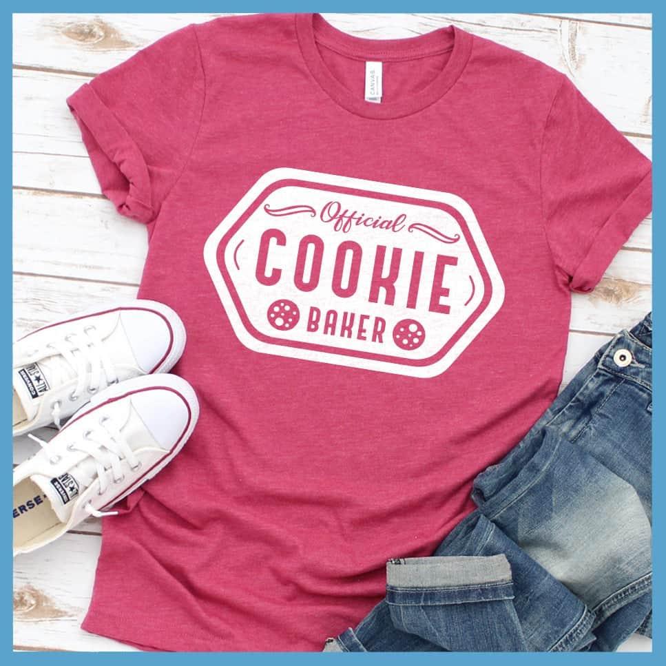Official Cookie Baker T-Shirt Heather Raspberry - Graphic tee with 'Official Cookie Baker' logo in a festive kitchen setting