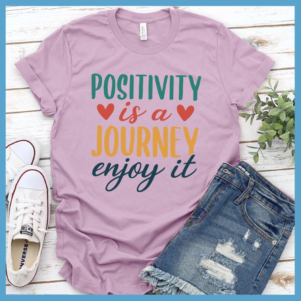 Positivity Is A Journey Enjoy It T-Shirt Colored Edition Lilac - Inspirational quote t-shirt with 'Positivity is a Journey Enjoy It' message.