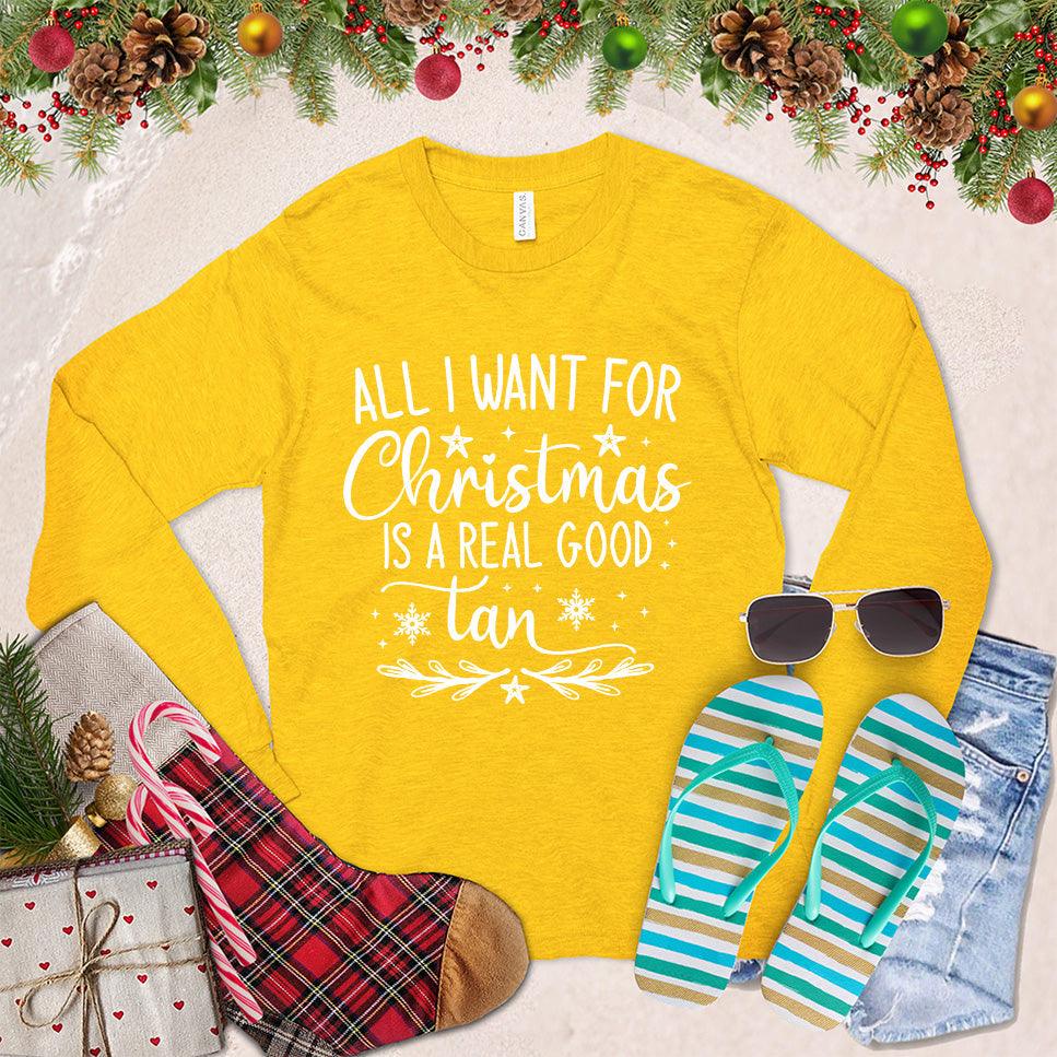 All I Want For Christmas Is A Real Good Tan Long Sleeves Gold - Holiday-themed long sleeve shirt with a whimsical Christmas and beach design, perfect for relaxed festive style.
