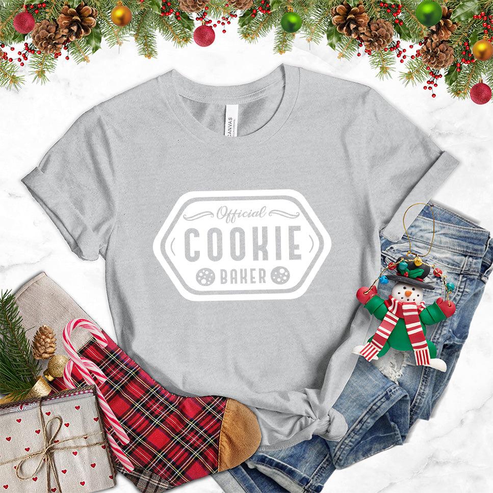 Official Cookie Baker T-Shirt Athletic Heather - Graphic tee with 'Official Cookie Baker' logo in a festive kitchen setting