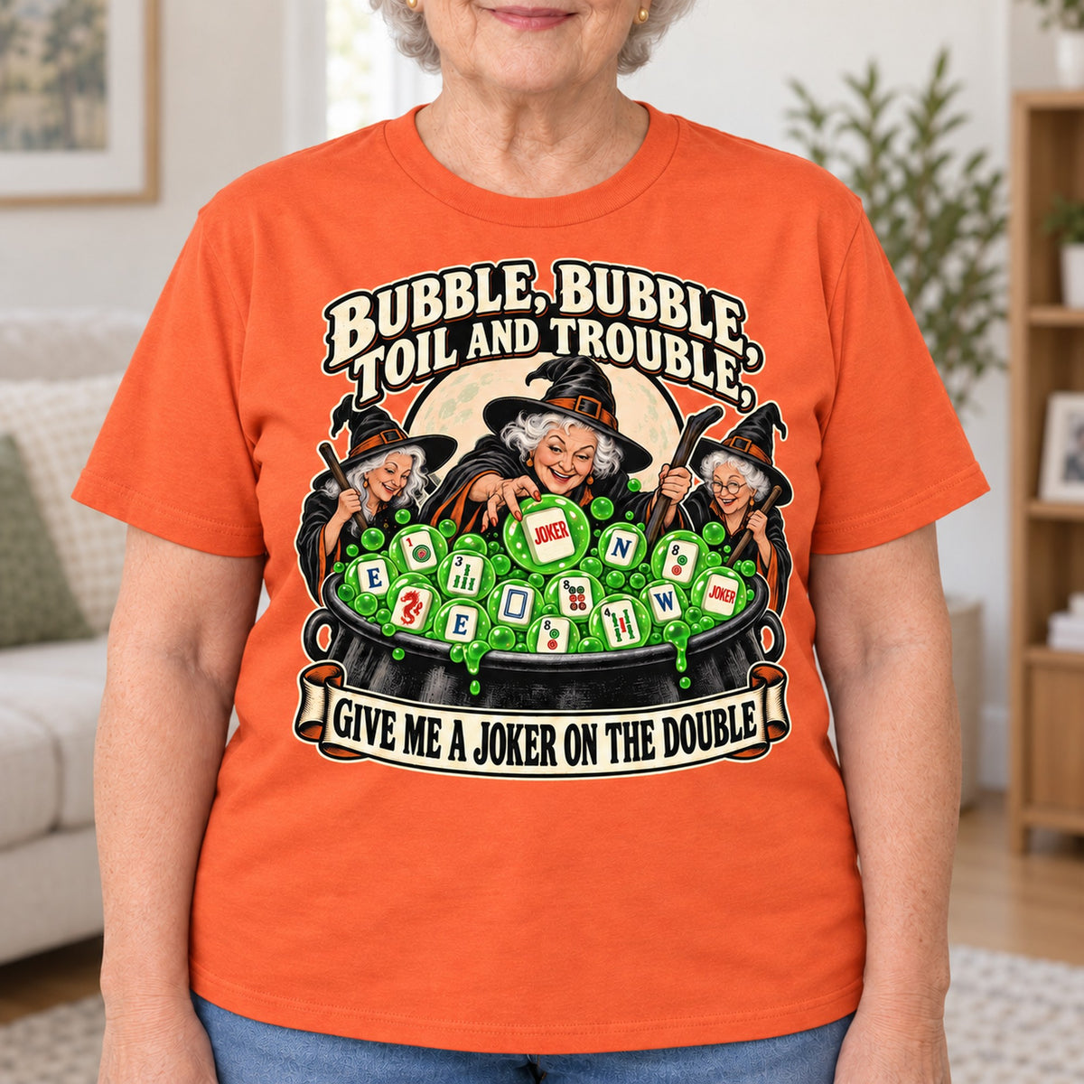 Toil And Trouble mahjong T-shirt in Orange, close-up of the print, worn by Joyce. Joyce is 5′5″ and wears her usual size L. [bb c=orange r=close]