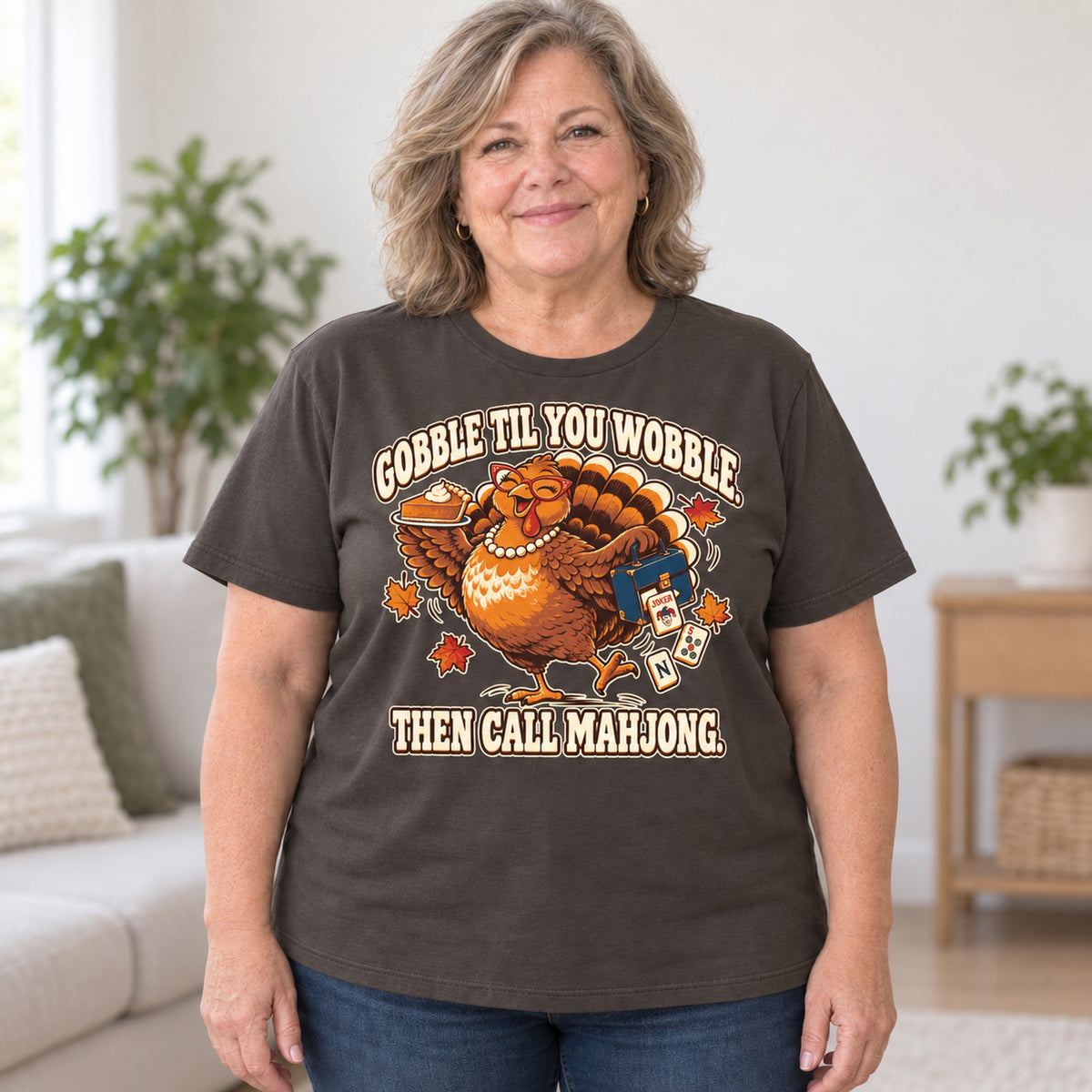 Gobble Til You Wobble mahjong T-shirt in Dark Chocolate, worn by Debra. Debra is 5′4″ and wears her usual size 2XL. [bb c=dark-chocolate r=body2]