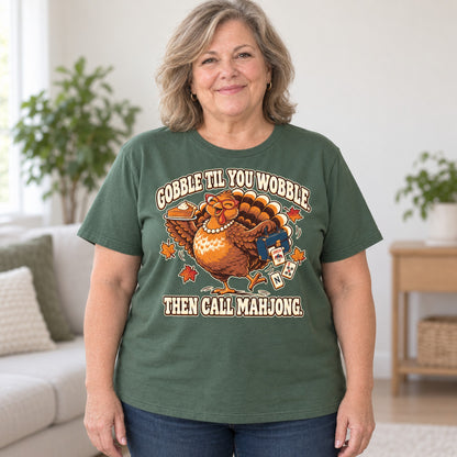 Gobble Til You Wobble mahjong T-shirt in Military Green, worn by Debra. Debra is 5′4″ and wears her usual size 2XL. [bb c=military-green r=body2]