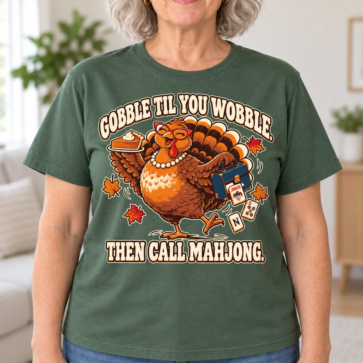 Gobble Til You Wobble mahjong T-shirt in Military Green, close-up of the print, worn by Donna. Donna is 5′5″ and wears her usual size L. [bb c=military-green r=close]