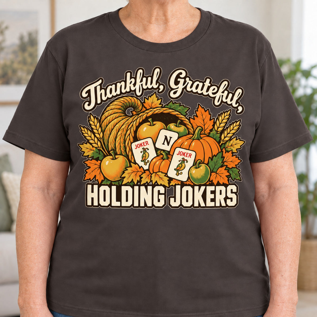 Thankful, Grateful, Holding Jokers mahjong T-shirt in Dark Chocolate, close-up of the print, worn by Barbara. Barbara is 5′5″ and wears her usual size L. [bb c=dark-chocolate r=close]