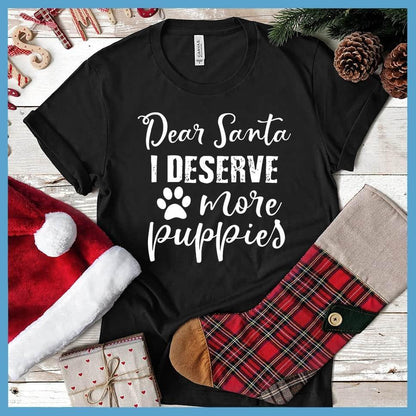 Dear Santa I Deserve More Puppies T-Shirt Black - Humorous holiday-themed T-shirt with 'Dear Santa I Deserve More Puppies' message in festive script.