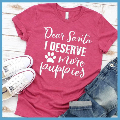 Dear Santa I Deserve More Puppies T-Shirt Heather Raspberry - Humorous holiday-themed T-shirt with 'Dear Santa I Deserve More Puppies' message in festive script.