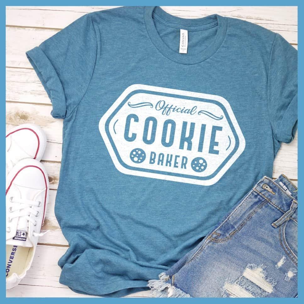Official Cookie Baker T-Shirt Heather Deep Teal - Graphic tee with 'Official Cookie Baker' logo in a festive kitchen setting