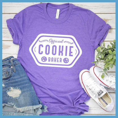 Official Cookie Baker T-Shirt Heather Purple - Graphic tee with 'Official Cookie Baker' logo in a festive kitchen setting