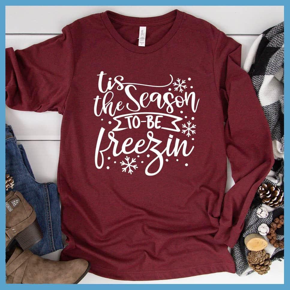 Tis The Season To Be Freezin Long Sleeves Heather Cardinal - Long sleeve winter shirt with whimsical snowflake design and festive phrase.